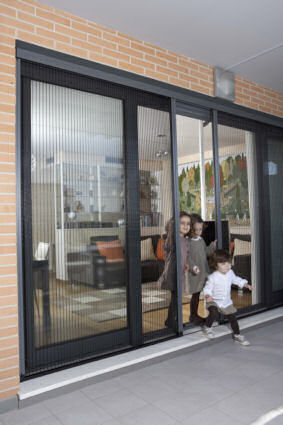 Moustiquaire latérale plissée installée devant une porte fenêtre aluminium